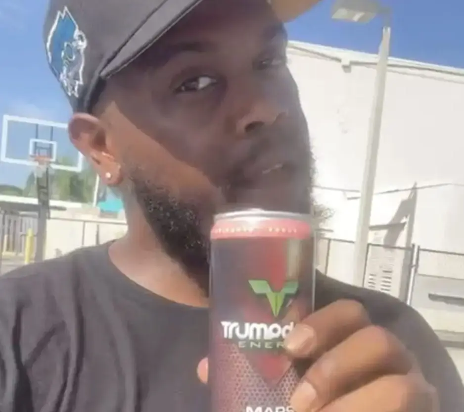 image of man holding trumpdrive energy drink